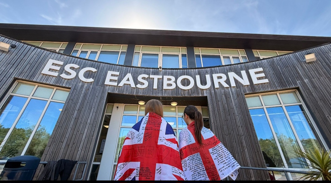 Due studentesse con bandiere britanniche davanti alla scuola ESC Eastbourne.
