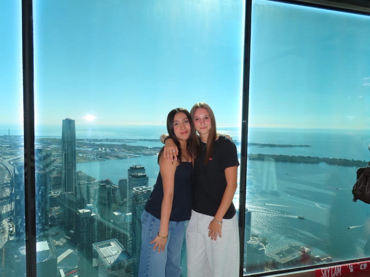 Due studentesse a Toronto davanti al panorama della città e del lago Ontario.